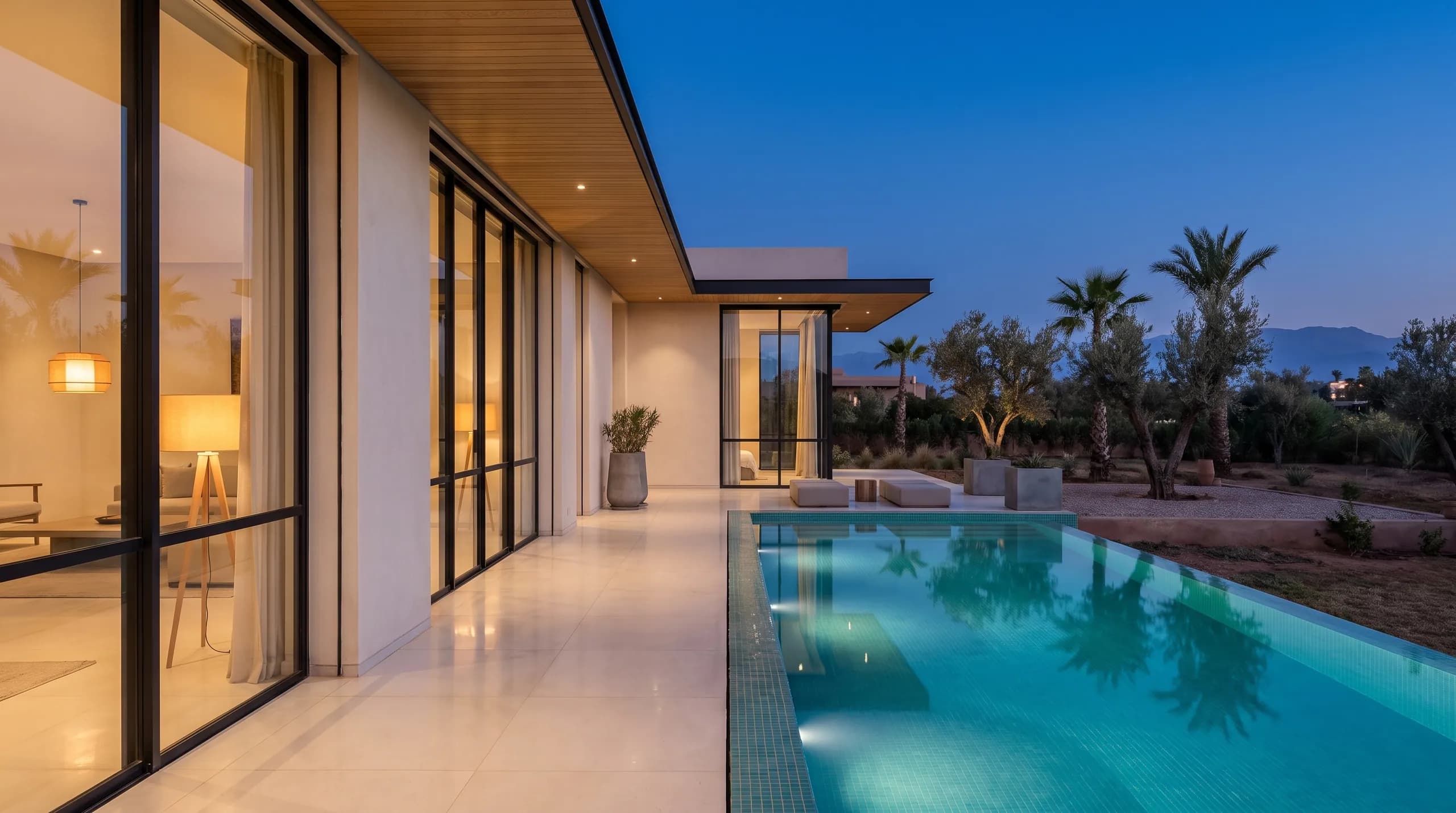 The villa at blue hour, every light on, cared for even while empty